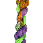 A skein of hand-dyed fingering/sock yarn color orange green purple black speckles
