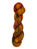 A skein of hand-dyed fingering/sock yarn color burnt orange red brown green speckles