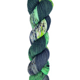A skein of hand-dyed fingering/sock yarn color green white grey black speckles