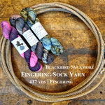 Skeins of Blackbird Sycamore Fingering/Sock Yarn on a wooden surface