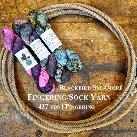 Skeins of Blackbird Sycamore Fingering/Sock Yarn on a wooden surface