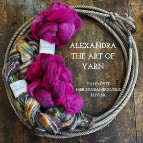 Braids of hand dyed wool bamboo silk roving on a wooden surface