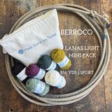 Mini balls of wool yarn with a zipper pouch on a wooden surface