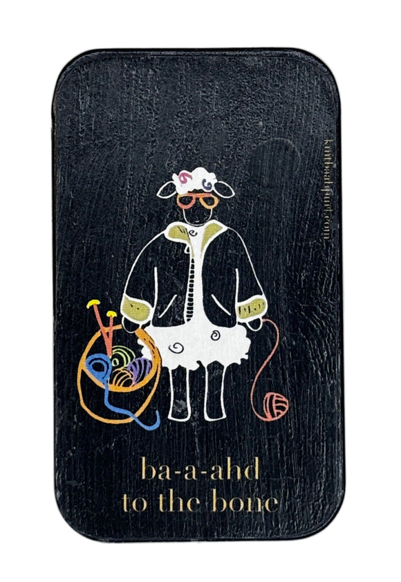 Small rectangular black tin with a cartoon design of a sheep with yarn on a white background
