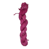 A skein of pink grey yarn on a white background