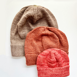 3 Base Doodle Beanies in various sizes knit up in brown orange and coral colored yarns