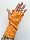 A Base Doodle Fingerless Mitt knit in a orange yarn worn on a hand