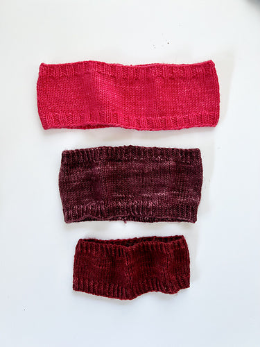 Base Doodle Headbands knit in various sizes in the colors red purple and red yarn