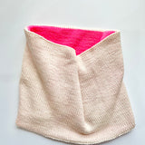 A Base Doodle Reversible Cowl knit in the colors off-white and pink
