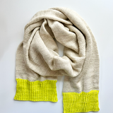 A Base Doodle Scarf knit in an off-white color with bright yellow ends