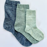 3 Base Doodle Socks knit in various sizes in navy blue green and light green yarn