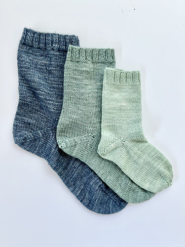 3 Base Doodle Socks knit in various sizes in navy blue green and light green yarn