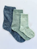 3 Base Doodle Socks knit in various sizes in navy blue green and light green yarn