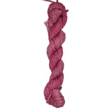 A skein of pink rose colored yarn on a white background