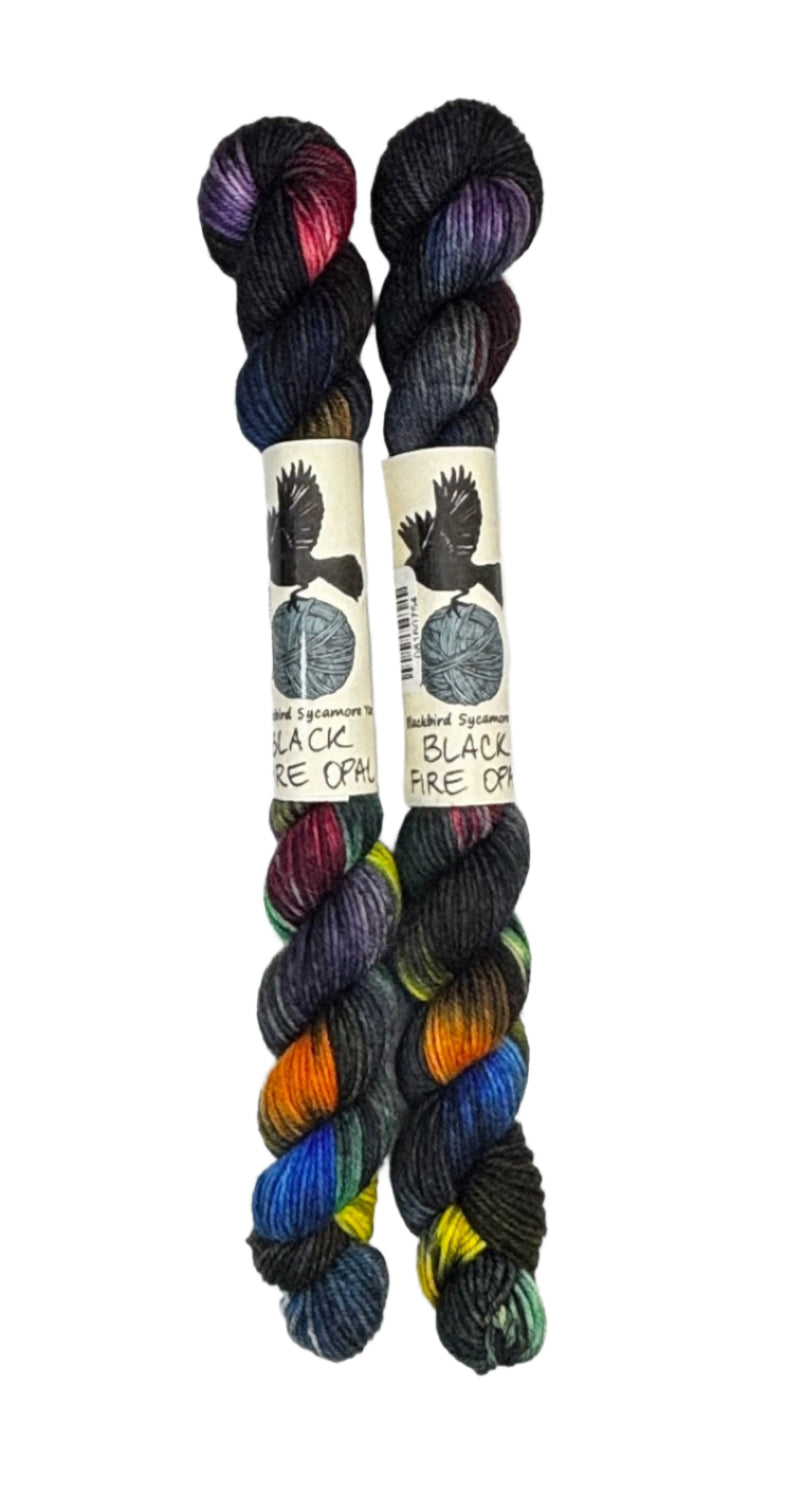 Two mini skeins of wool yarn hand dyed in Wyoming in the color black red orange yellow blue green