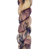 A skein of hand-dyed fingering/sock yarn color tan mauve navy brown