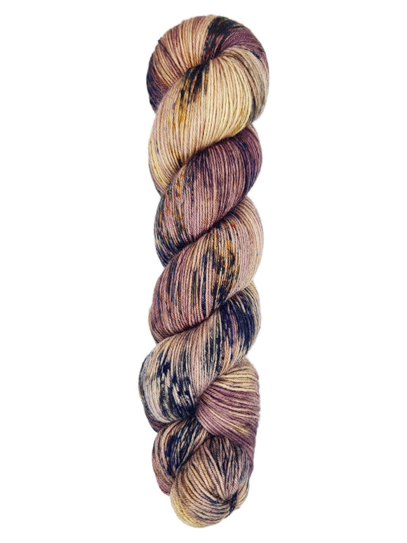A skein of hand-dyed fingering/sock yarn color tan mauve navy brown