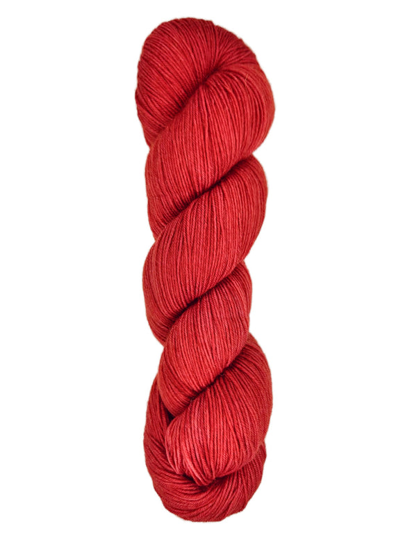 A skein of hand-dyed fingering/sock yarn color red