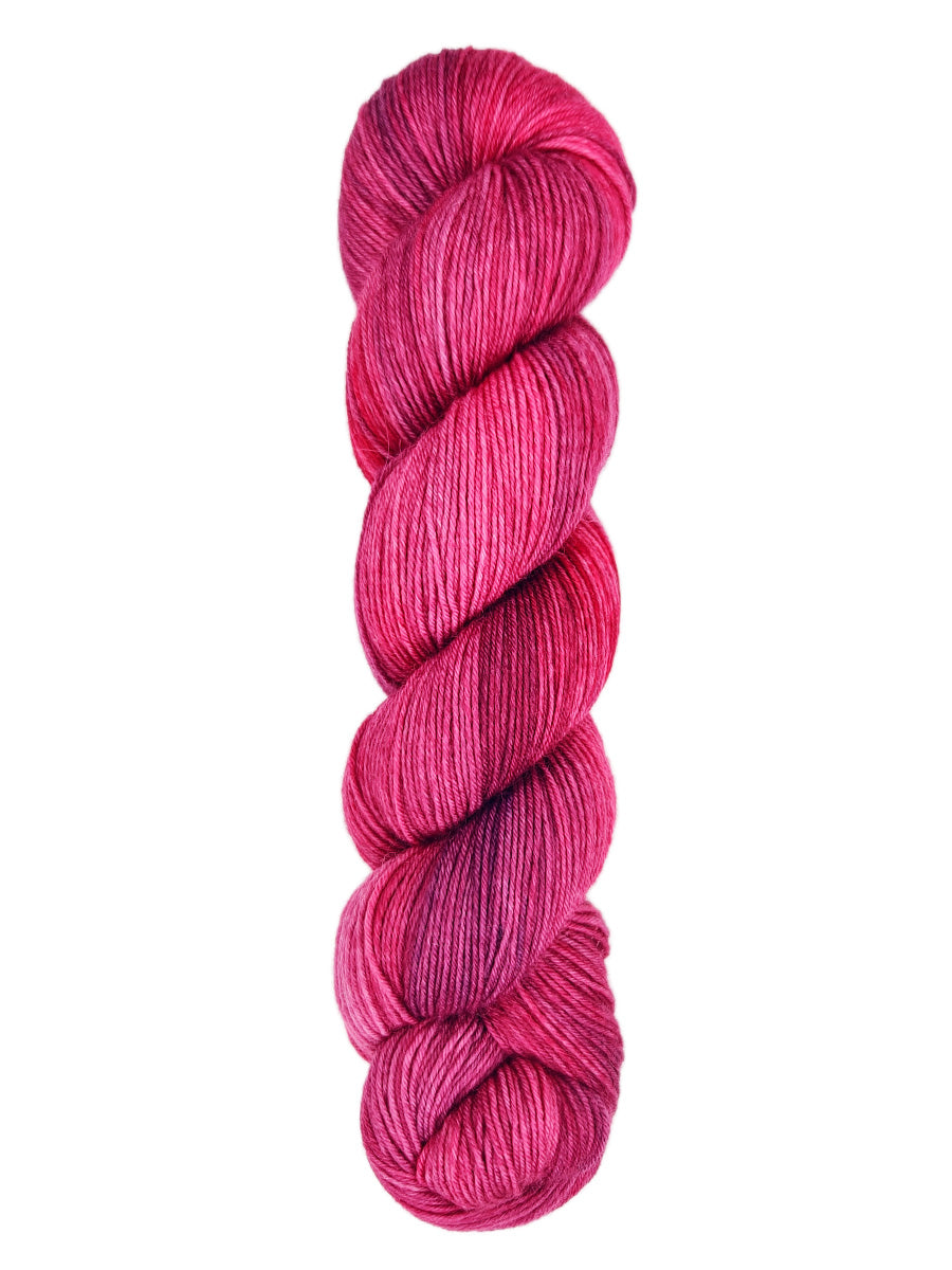 A skein of hand-dyed fingering/sock yarn color red pink
