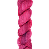 A skein of hand-dyed fingering/sock yarn color red pink