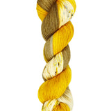 A skein of hand-dyed fingering/sock yarn color brown and gold speckles