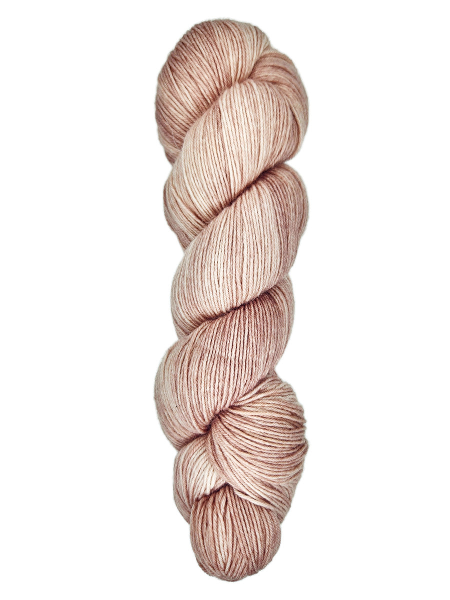 A skein of hand-dyed fingering/sock yarn color dusty pink
