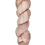 A skein of hand-dyed fingering/sock yarn color dusty pink