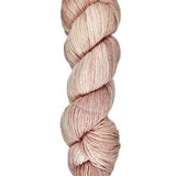 A skein of hand-dyed fingering/sock yarn color dusty pink