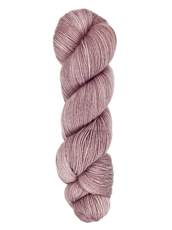 A skein of hand-dyed fingering/sock yarn color dusty pink