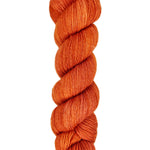A skein of hand-dyed fingering/sock yarn color burnt orange