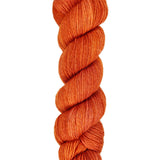 A skein of hand-dyed fingering/sock yarn color burnt orange