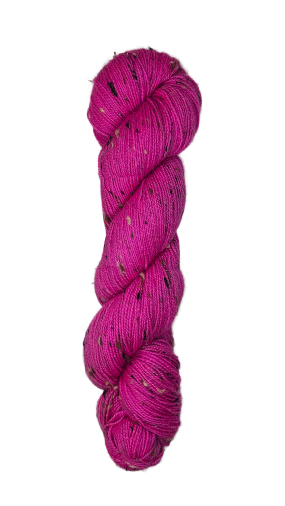 Skein of hand dyed BFL Tweed yarn in a neon pink color