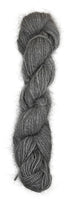 A handspun skein of angora and merino yarn in a natural grey color