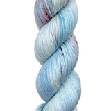 A skein of hand-dyed fingering/sock yarn color white blue grey red speckles