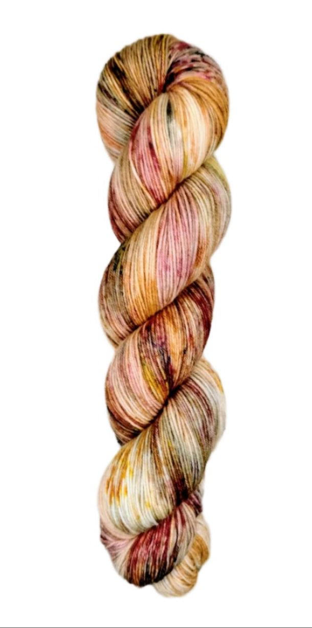 A skein of hand-dyed fingering/sock yarn color orange red white brown speckles