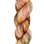 A skein of hand-dyed fingering/sock yarn color orange red white brown speckles