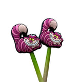 Pink cheshire cat stitch stoppers on wooden needles against a white background