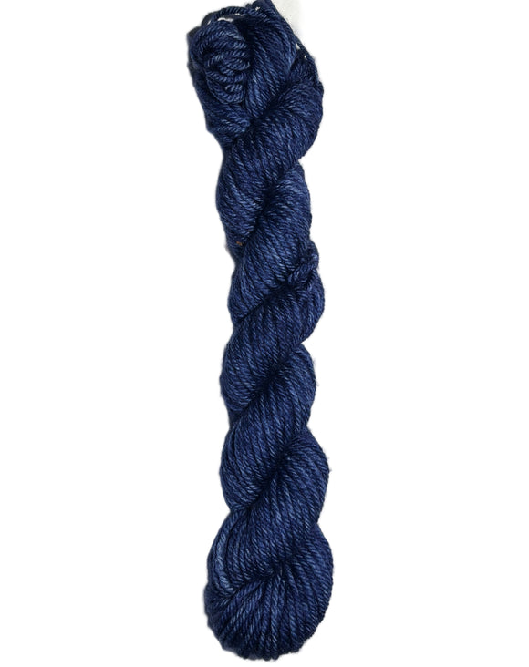 Dark blue skein of wool yarn on a white background