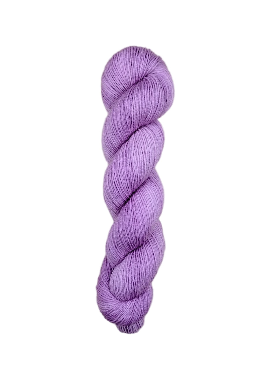 Purple skein of yarn on a light wooden surface