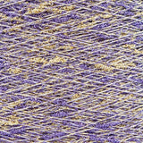 Close-up of Crocus Gold White, a white base yarn with purple and gold sparkles