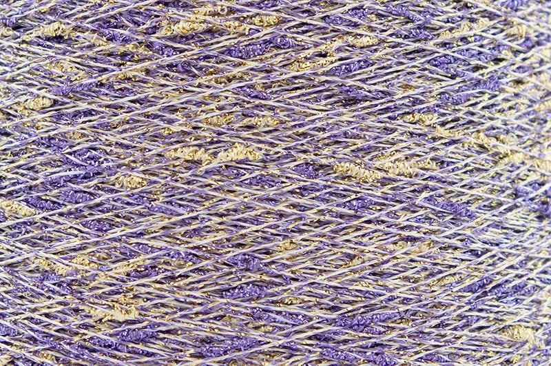 Close-up of Crocus Gold White, a white base yarn with purple and gold sparkles