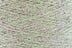 Close-up of Green-Pink White, a white base yarn with light green and pink sparkles