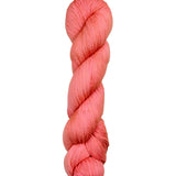 A skein of hand-dyed fingering/sock yarn color salmon pink
