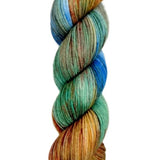 A skein of hand-dyed fingering/sock yarn color green orange blue red brown speckles