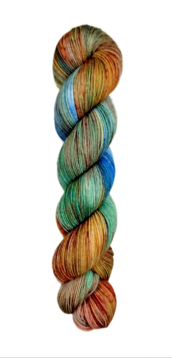A skein of hand-dyed fingering/sock yarn color green orange blue red brown speckles