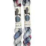 Two mini skeins of wool yarn hand dyed in Wyoming in the color white blue black red