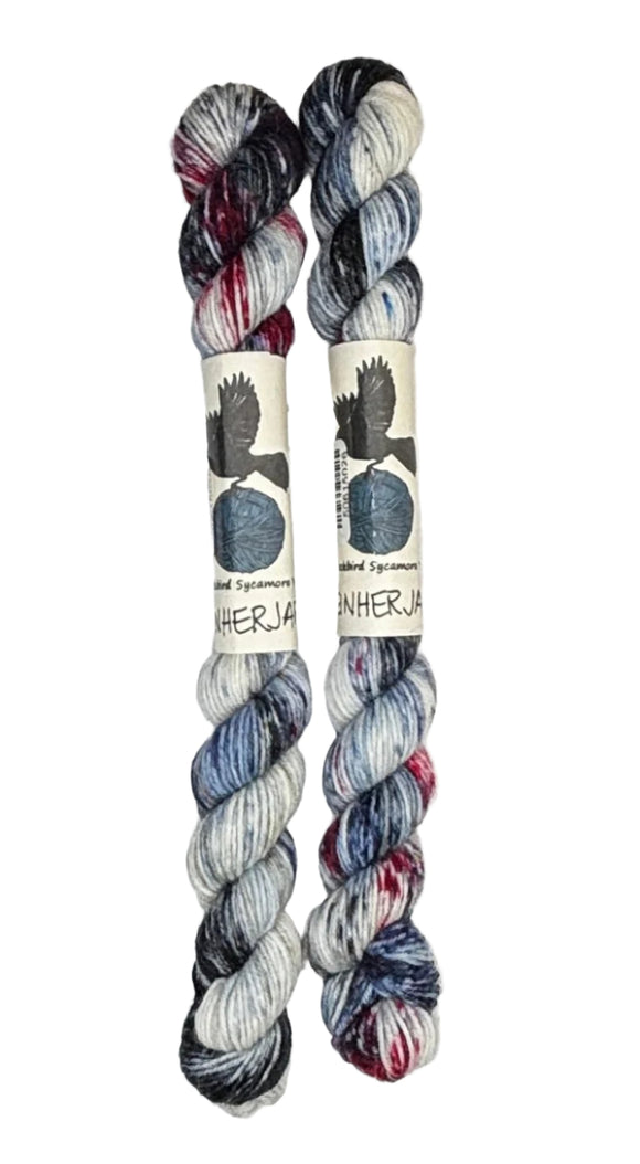 Two mini skeins of wool yarn hand dyed in Wyoming in the color white blue black red