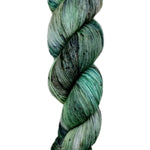 A skein of hand-dyed fingering/sock yarn color grey green black speckles
