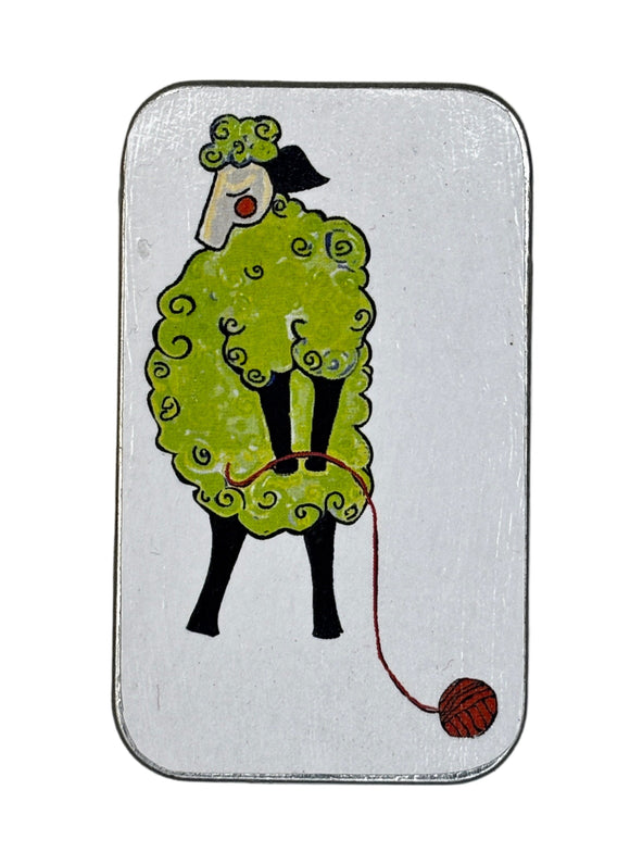 Small rectangular tin with a cartoon design of a sheep with some yarn on a white background