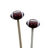 Two football-shapedstitch stoppers with smiling faces on knitting needles